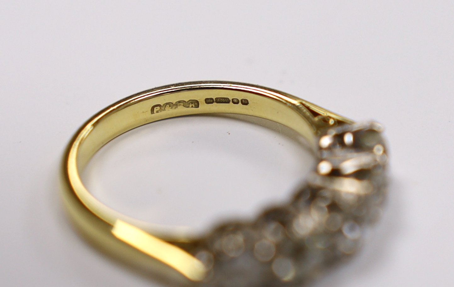 A modern 18ct gold and graduated five stone diamond set half hoop ring, size M, gross weight 4.5 grams.